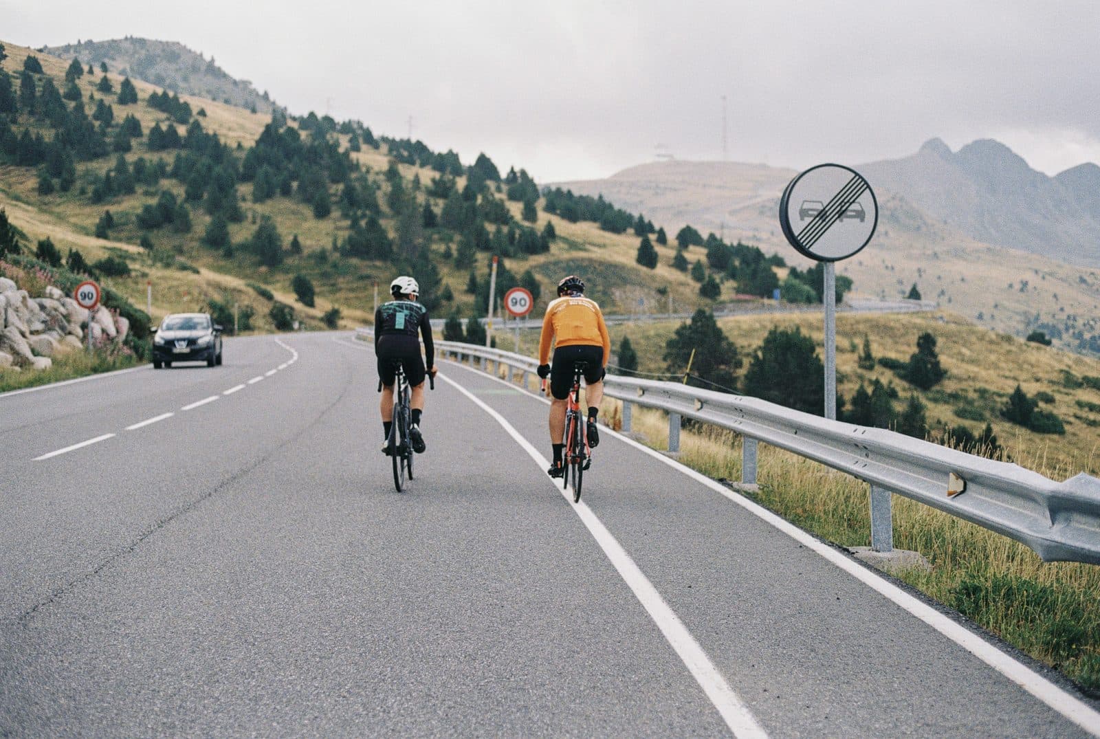 Dos ciclistas rodando juntos por una carretera de montaña